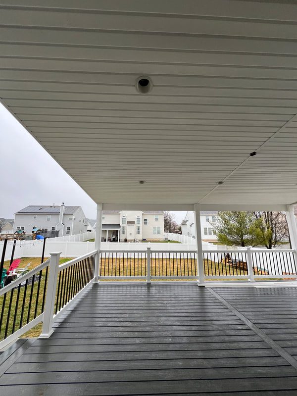 A Porch With White Railings and a Black Roof