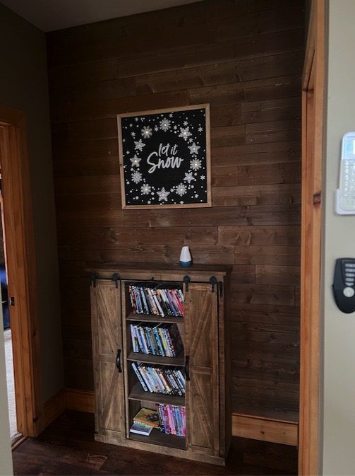 A Wooden Door With a Bookshelf and a Sign on the Wall