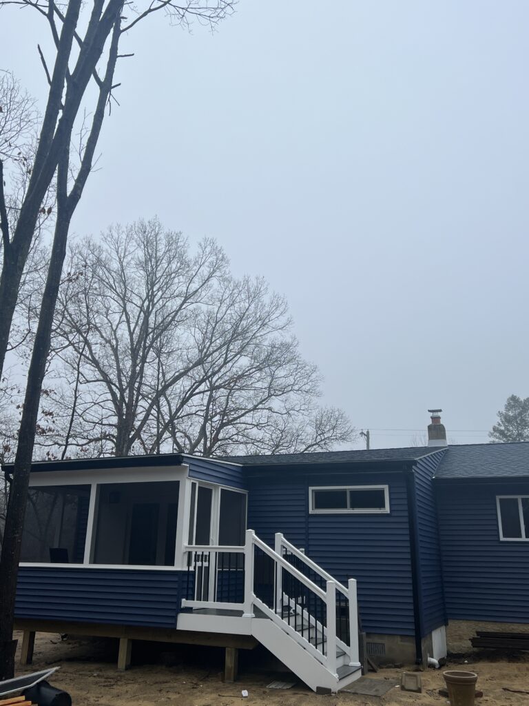 Lovely Blue House Featuring Porch and Tree